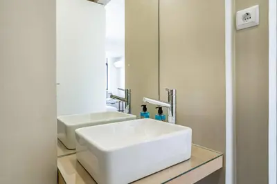 a bathroom with a white sink and a mirror at Downtown Private Rooftop Experience in Porto