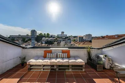 a couch on a balcony with a view of a city at Downtown Private Rooftop Experience in Porto