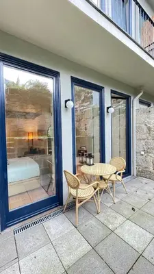 a patio with a table and chairs and a bedroom at Sol Garden in Porto
