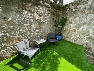 two chairs and a table in a room with green grass at Sol Garden in Porto