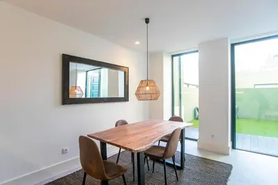 a dining room with a table and chairs and a mirror at Loulé Luxury Garden W/ AC in Porto