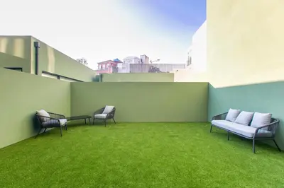 a patio with chairs and grass on a building at Loulé Luxury Garden W/ AC in Porto