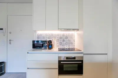 a kitchen with white cabinets and a stove at Loulé Luxury Garden W/ AC in Porto