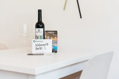 a bottle of wine and a book on a table at GuestReady - Amazing Studio in the heart of Porto in Porto