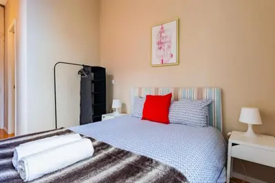 a bedroom with a bed with a red pillow at Classy Flat at Marques Square with Garden in Porto