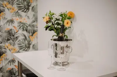 a white table with a vase with flowers in it at Nature Cosy Private House,w/AC Downtown near Metro in Porto
