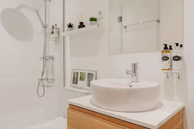 a white bathroom with a sink and a shower at Nature Cosy Private House,w/AC Downtown near Metro in Porto
