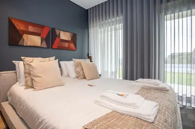 a bedroom with a large bed with towels on it at Liiiving in Porto - Dragão Pool View in Porto
