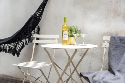 a table with a bottle of wine and two chairs at BmyGuest - Patio de Santa Catarina Apartment in Porto