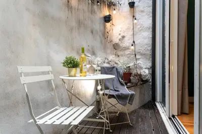 a table with a bottle of wine and a chair at BmyGuest - Patio de Santa Catarina Apartment in Porto