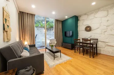 a living room with a couch and a dining room at BmyGuest - Patio de Santa Catarina Apartment in Porto