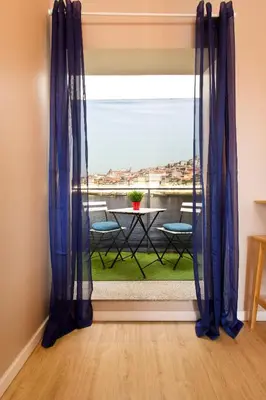 a room with a window with a table and chairs at Oporto Blue Lapa - Spacious Family Apartment With Winter Garden in Porto