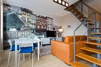 a living room with a table and chairs and a staircase at Oporto Blue Lapa - Spacious Family Apartment With Winter Garden in Porto