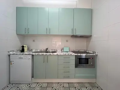 a kitchen with blue cabinets and a sink and a microwave at Oporto Blue Lapa - Spacious Family Apartment With Winter Garden in Porto