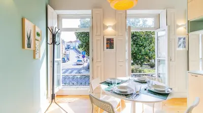 a dining room with a table and chairs and windows at Barros Lima 493 by LovelyStay in Porto