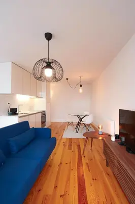 a living room with a blue couch and a table at HM – Historic Downtown Batalha Studio in Porto