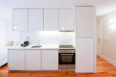 a kitchen with white cabinets and a sink at HM – Historic Downtown Batalha Studio in Porto