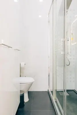 a bathroom with a toilet and a glass shower at ORM Catedral & São Bento & Luiz Apartments in Porto