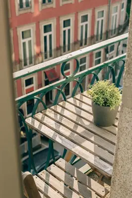 a wooden table with a potted plant on a balcony at ORM Catedral & São Bento & Luiz Apartments in Porto