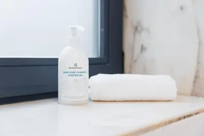 a bottle of laundry detergent next to a stack of towels at HiddenGem - Cherry on Top in Porto