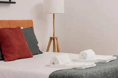 a bed with white towels on it with a lamp at Rodrigues de Freitas 391 by LovelyStay in Porto