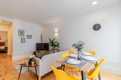 a living room with a table and yellow chairs at Rodrigues de Freitas 391 by LovelyStay in Porto