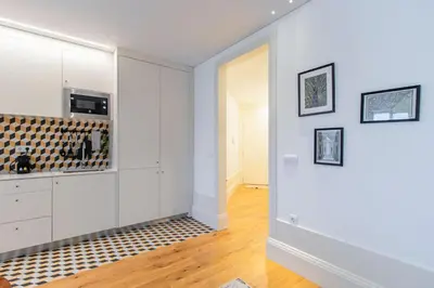 a kitchen with white cabinets and a black and white rug at Rodrigues de Freitas 391 by LovelyStay in Porto