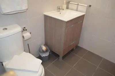 a bathroom with a white toilet and a sink at Sense Porto in Porto