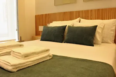 a bedroom with a bed with towels on it at Oporto Prime Studios in Porto