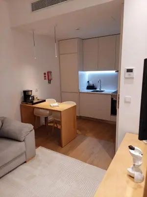 a small living room with a table and a kitchen at Oporto Prime Studios in Porto