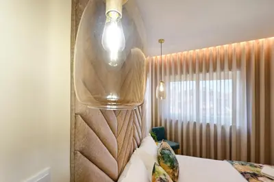 a hotel room with a bed and a light above it at Lapa City Flat Porto - by Guest SPA in Porto