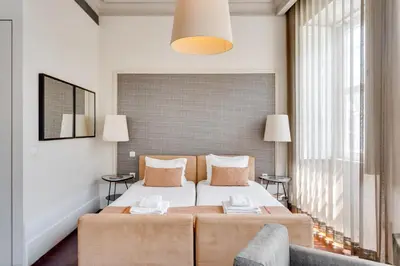 a bedroom with a bed and a large window at Traça Apartments by DA'HOME in Porto