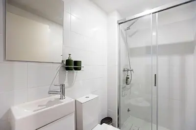 a white bathroom with a sink and a shower at Cimo de Vila 62 by LovelyStay in Porto
