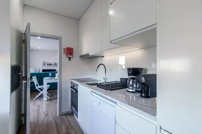 a kitchen with white cabinets and a counter top at Downtown 1BR Apartment W/ Balcony by LovelyStay in Porto