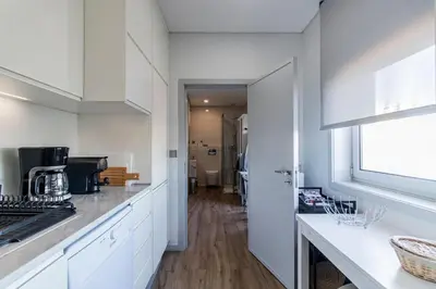 a kitchen with white cabinets and a counter top at Downtown 1BR Apartment W/ Balcony by LovelyStay in Porto