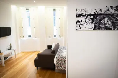 a living room with a couch and a picture of the eiffel tower at Porto Santa Maria Apartments in Porto