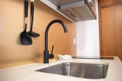 a kitchen sink with utensils on the wall at Apartment T1 - Porto in Porto
