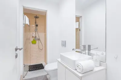 a white bathroom with a sink and a toilet at GuestReady - Bright home in the heart of Porto in Porto
