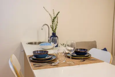 a table with glasses and plates and a sink at AgapeStay Porto in Porto