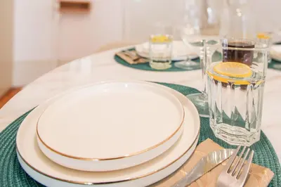 a table with plates and forks and a glass at Aliados Sunny Flat in Porto