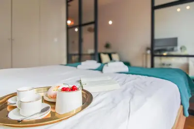a tray with two cups and a plate of food on a bed at Aliados Sunny Flat in Porto