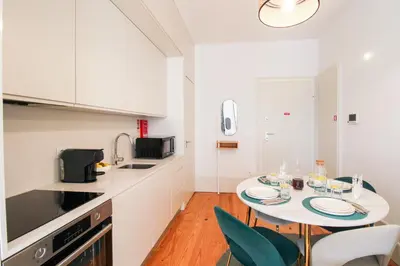 a kitchen with a table and chairs in a room at Aliados Sunny Flat in Porto