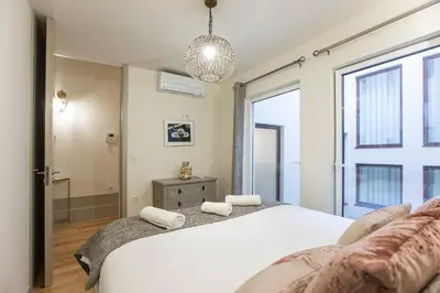a bedroom with a white bed and a large window at Alma do Porto - With AC in Porto