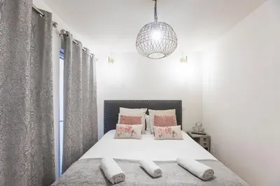 a bedroom with a white bed with pink pillows at Alma do Porto - With AC in Porto