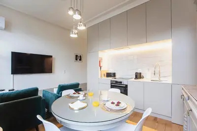 a kitchen and living room with a table and chairs at Alma do Porto - With AC in Porto