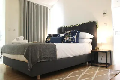 a bedroom with a large bed with blue pillows at Amazing Flores Duplex in Porto