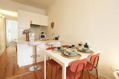 a kitchen with a table and chairs with wine glasses at Cativo Design Apartment in Porto