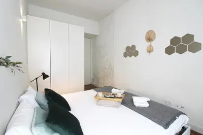 a white room with a white couch and a bed at Cativo Design Apartment in Porto