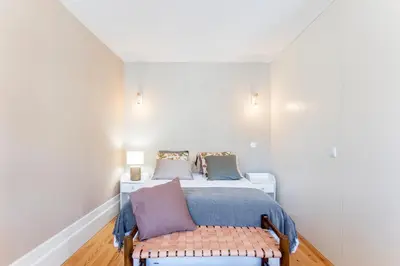 a bedroom with a bed and a bench in it at Cosy Flat Near Douro in Porto
