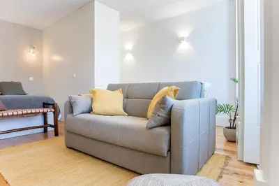 a living room with a couch and a bedroom at Cosy Flat Near Douro in Porto